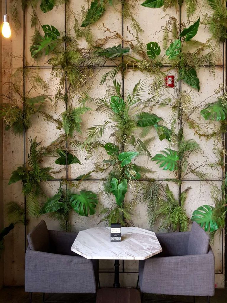 sitting area with greenery in the background at coffee shop